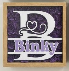 Black Shadowbox with initial and name surrounded by colorful hand rolled flowers